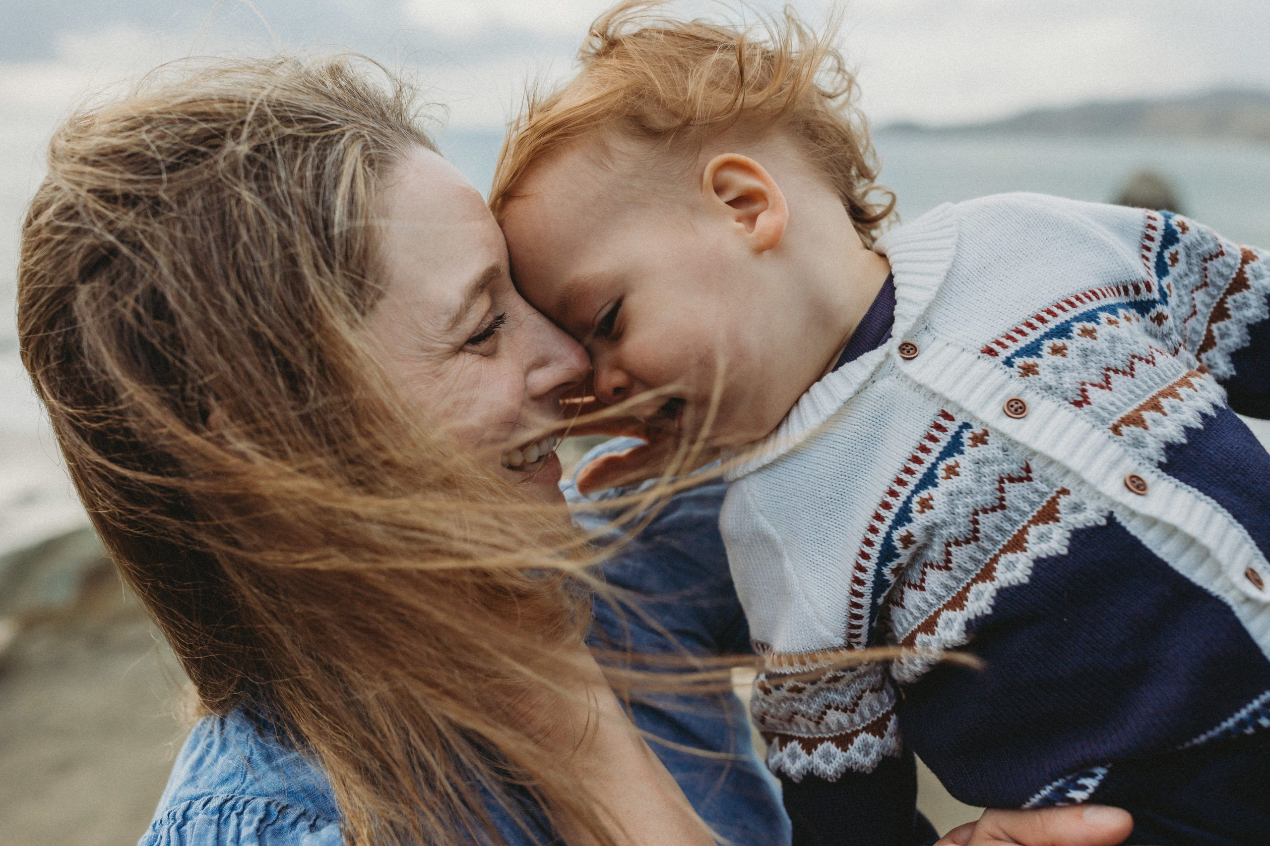 mother and son touching faces with windswept hair in California - outdoor family photographer