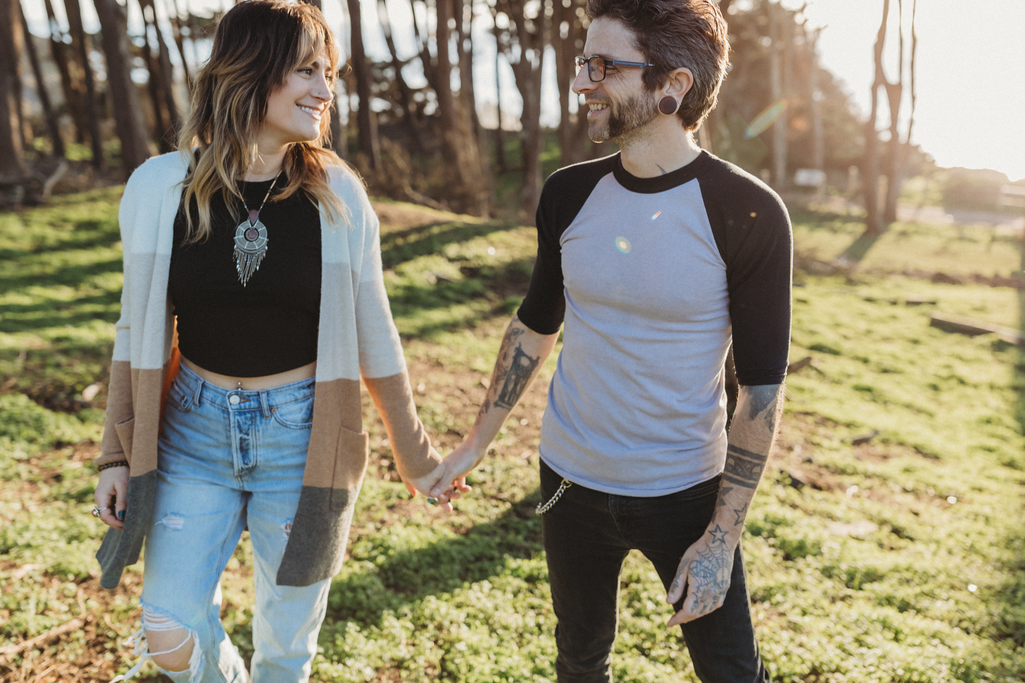 Couple holding hands and laughing together at their engagement photo shoot at the Sutro Baths in San Francisco, California. Tips for feeling comfortable in front of the camera.