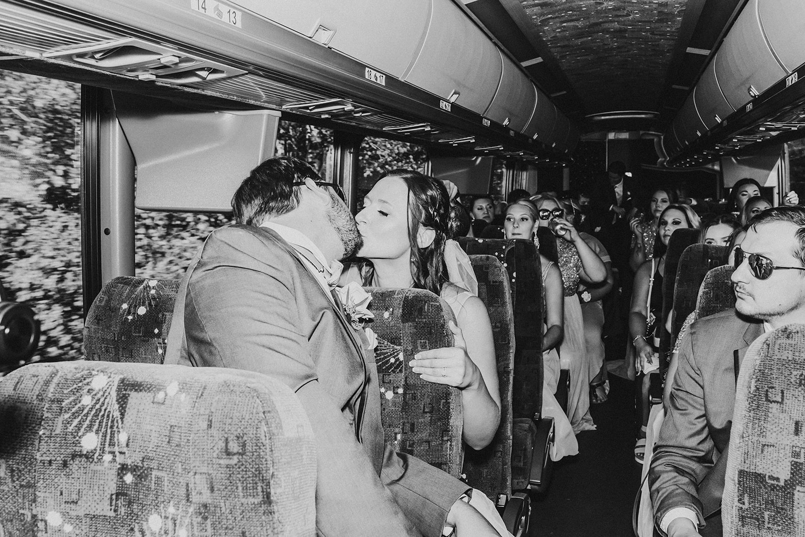 Bride and groom kissing on party bus