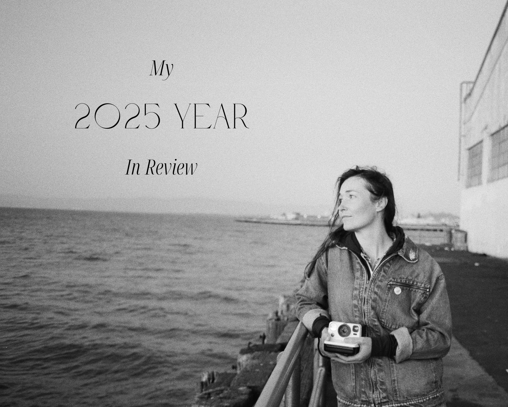 Girl leaning against railing on San Francisco pier with Polaroid camera in hand.