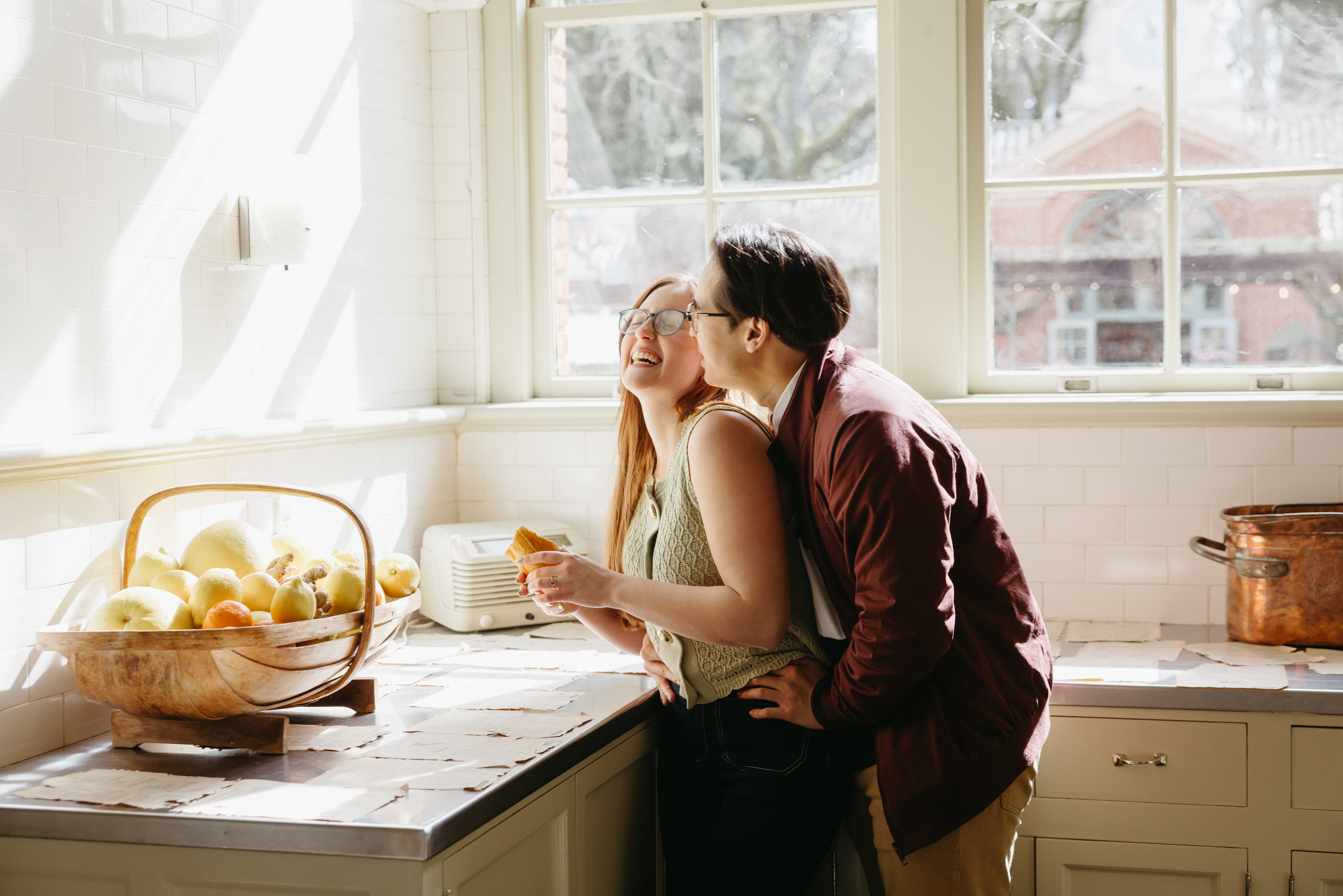 Playful photo of a man kissing a woman on her cheek inside Filoli Historic House in California. Taken by Skyler Maire Photography.