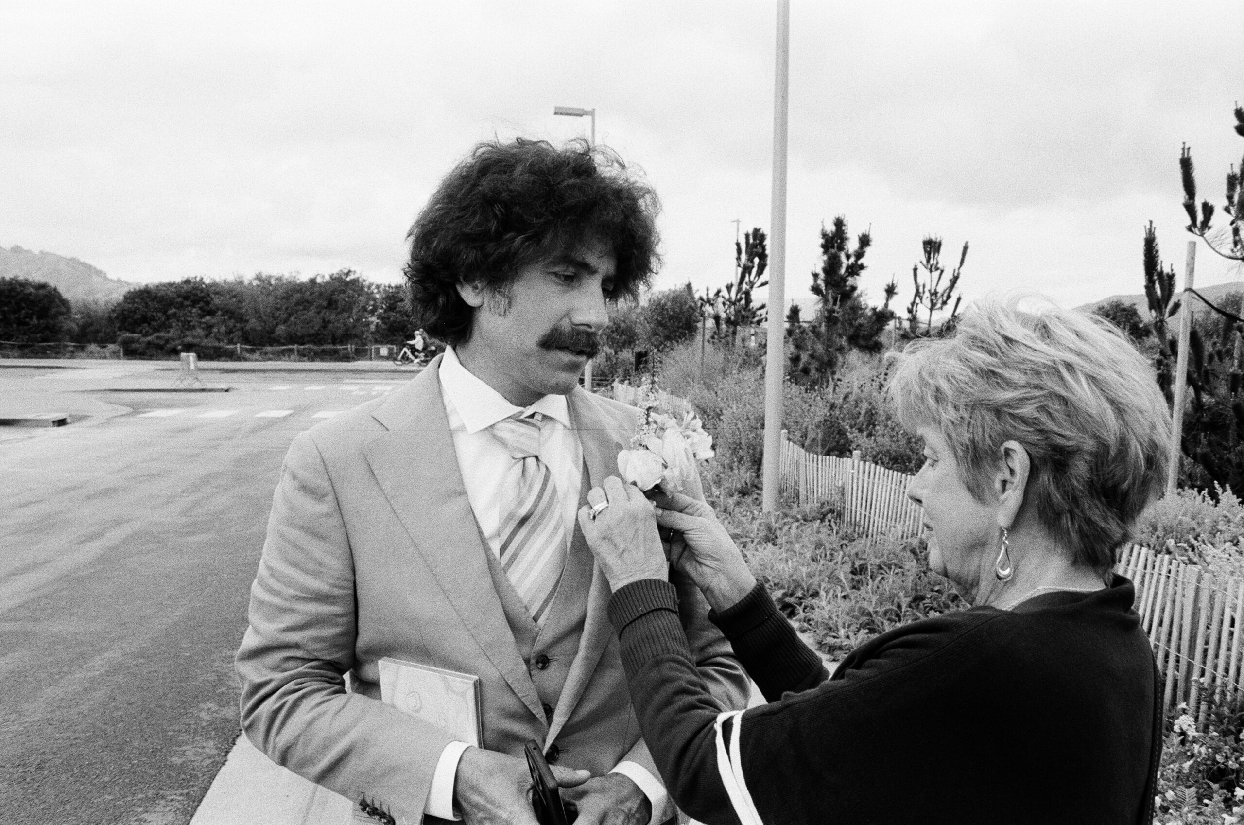 A mother fixes a boutonniere to her son's suit before his wedding ceremony in San Francisco, California.