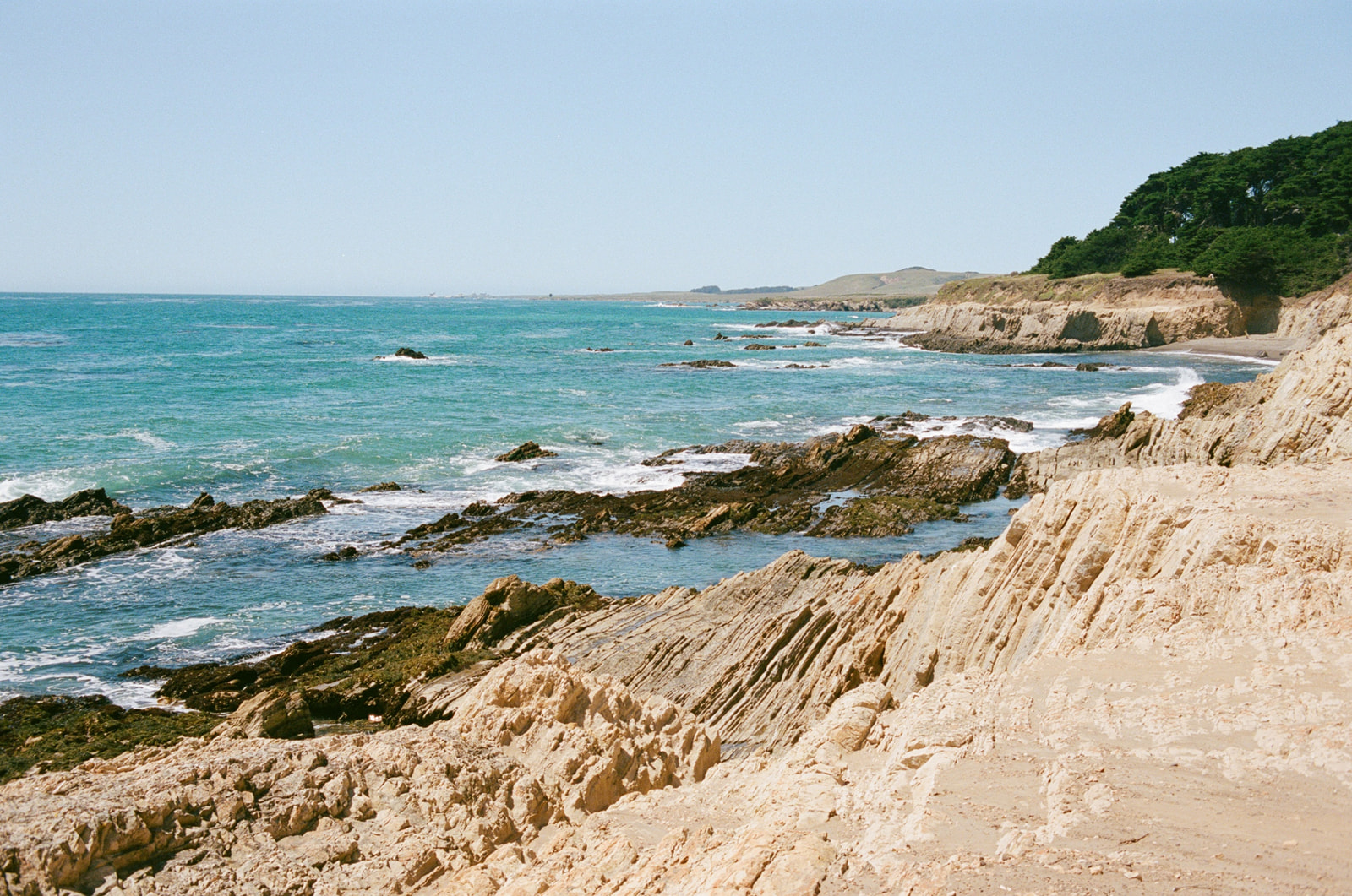 A rocky coastline filled with tide pools on the West Coast. Taken by Skyler Maire Photography.