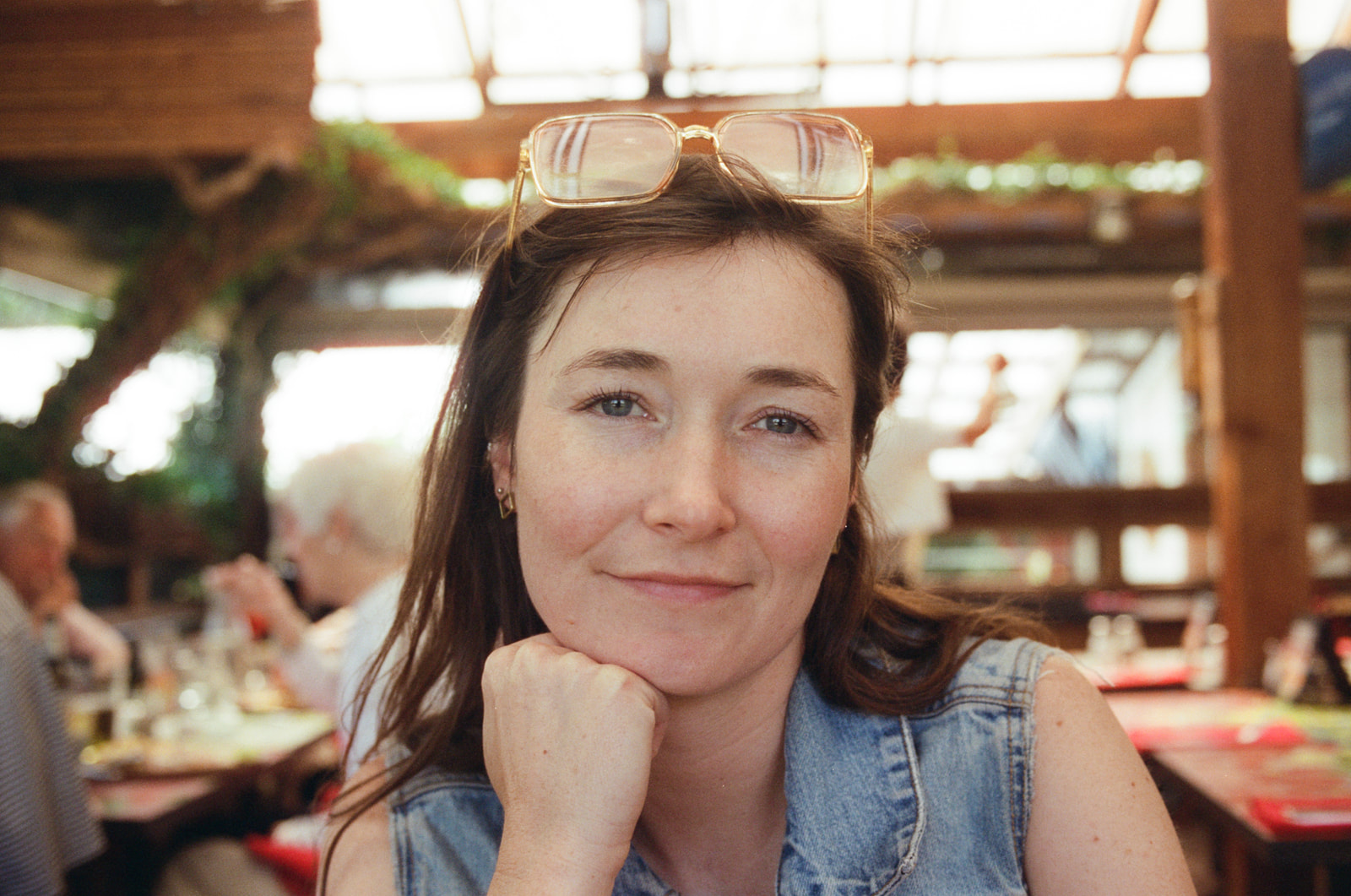 Close up of a girl smiling at the camera while resting her chin on her hand in Cambria, California.
