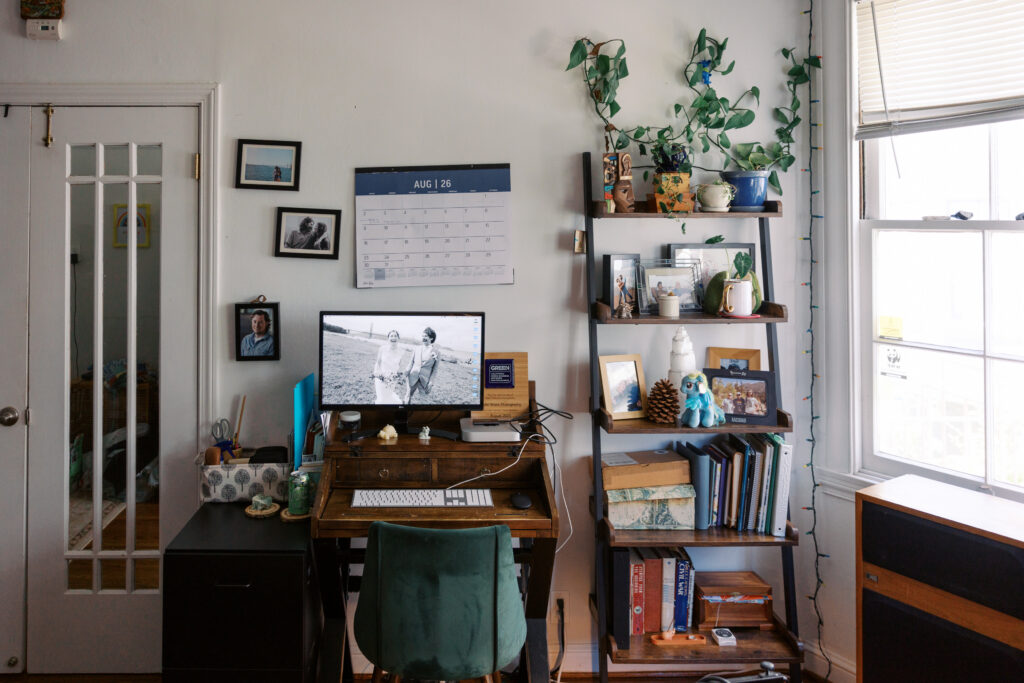 A small desk, chair, filing cabinet and shelf that makes a small office in a studio apartment.