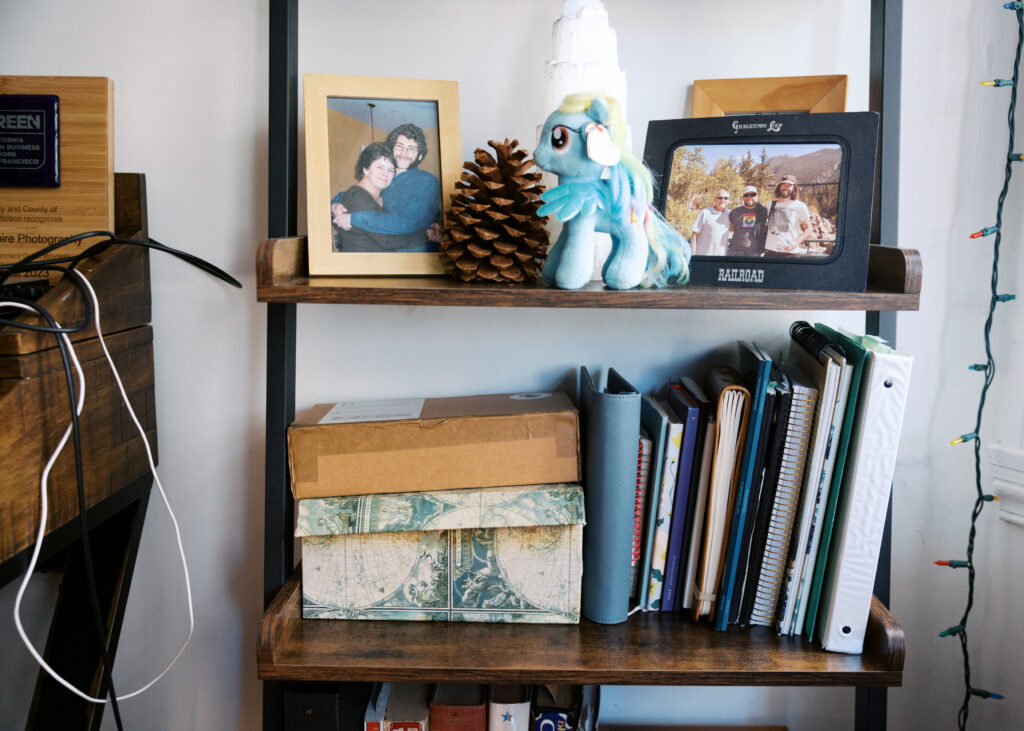 Photos, journals, binders, and other special items on a shelf in a home office.